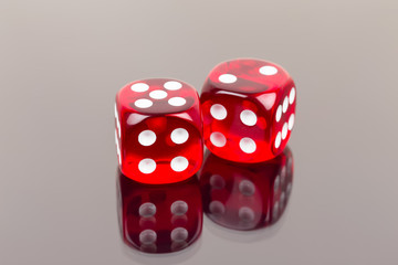 Two red dice with reflection