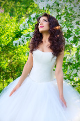 Bride on the background of blooming apple trees