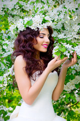 Bride on the background of blooming apple trees