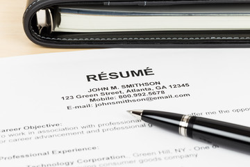 Resume with pen and organizer; resume and information are mock-u