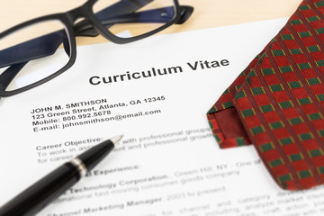 Curriculum vitae or CV with pen, glasses, and neck tie; CV and i