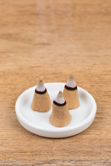 Burning incense cone on plate