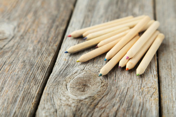 Colour pencils on grey wooden background