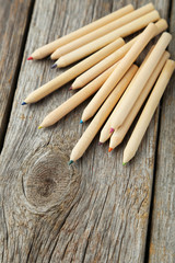 Colour pencils on grey wooden background