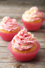 Tasty cupcake on grey wooden background