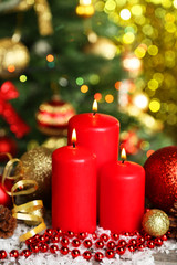 Christmas balls and candles on grey wooden background