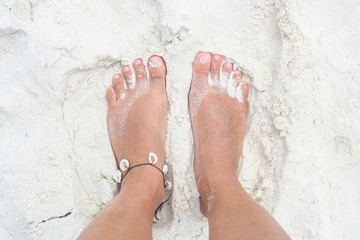 Feet on the white sand.