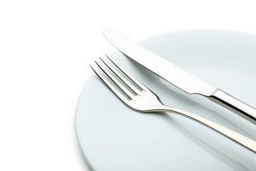 Fork, knife and plate on white background