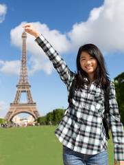 Young attractive asian tourist in front of Eiffel tower