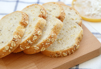 Sliced white bread on wooden plate