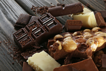 Set of chocolate with hazelnut on wooden table, closeup