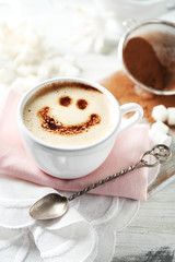 Cup of latte coffee art on wooden table, on light background