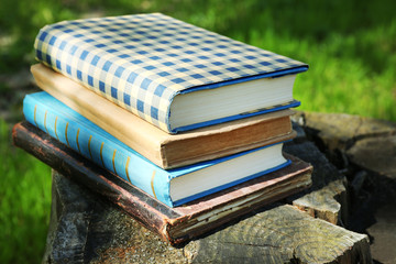 Stacked books in grass, outside