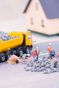 Road works with miniature workers close-up