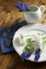 Tableware with flowers on table close up