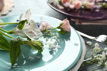 Tableware with flowers on table close up