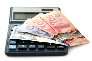Calculator and Canadian dollars, isolated on white