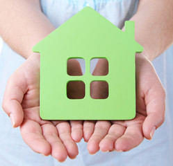 Female hands with small model of house, closeup