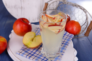 Glass of apple cider with fruits on table close up