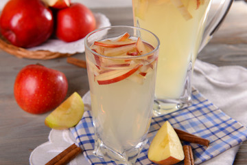 Glasses of apple cider with fruits on table close up
