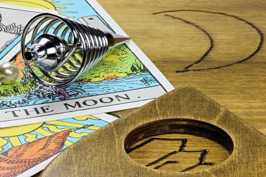 Tarotkarte THE MOON mit Pendel auf Ouija