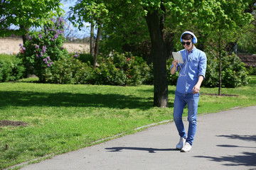 Fototapeta premium Man walking with headphones in park