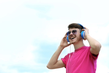 Man with headphones over blue sky background