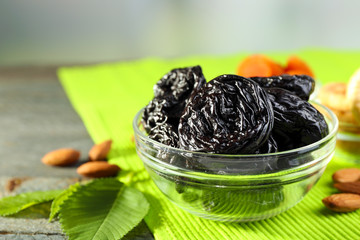 Dried fruits and almonds with leaves on green napkin, closeup