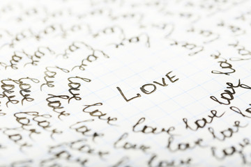 Words LOVE written on sheet of paper background