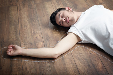 Crime scene simulation, young man lying on floor