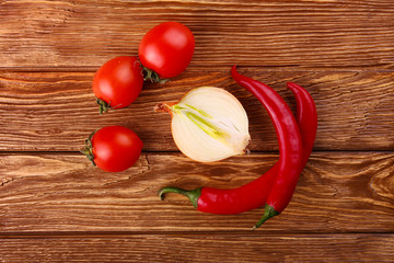 Red hot cherry and chili peppers over white wooden background onion