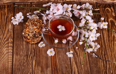 tea and a branch of cherry blossoms on a wooden