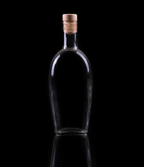 Bottle and glass with alcohol isolated on black.