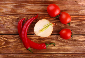 Red hot cherry and chili peppers over white wooden background onion