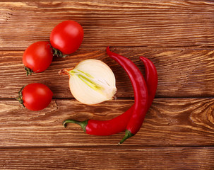 Red hot cherry and chili peppers over white wooden background onion