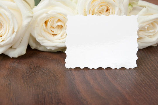 the white roses on a wooden background with a space for your tex