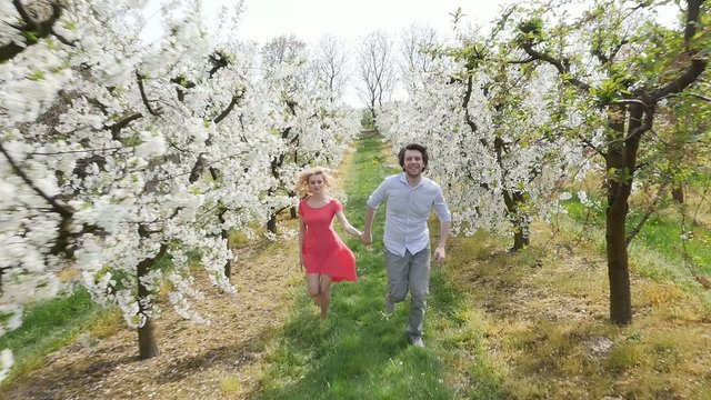 Cheerful couple enjoying leisure time in the fragrant orchard