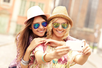 Two happy girl friends taking selfie