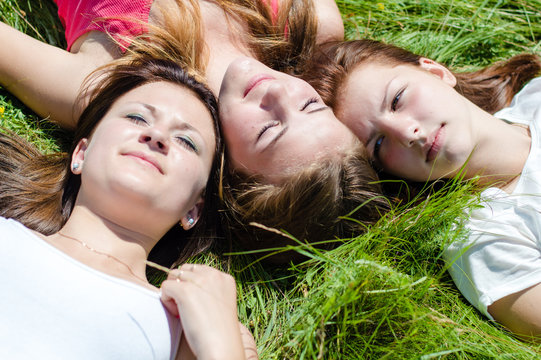 Three teen girls lying on grass