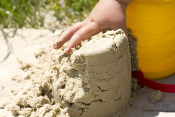 child plays builds towers of sand