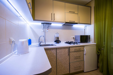 Fototapeta na wymiar Modern small kitchen with green curtains