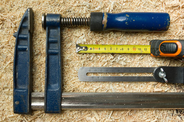 Carpenter tools on wooden table with sawdust. Workplace top view