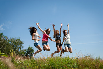 4 beautiful happy teen girls friends jumping