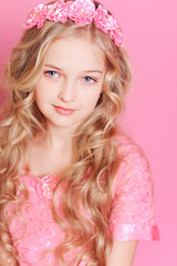 Naklejka premium Pretty kid girl posing over pink