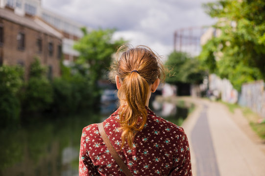 Young woman standing by a canal in the spring