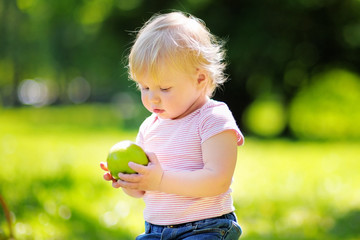 Toddler boy eating fresh green apple