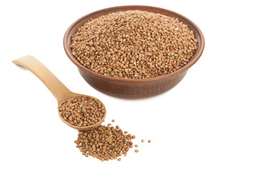 Buckwheat in bowl with wooden spoon on white.