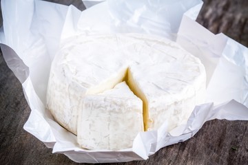 Whole Camembert cheese and portion