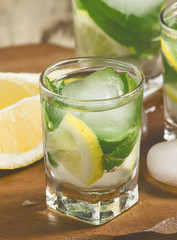 Glass of water with fresh lemon, ice and mint, selective focus