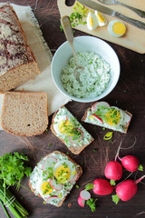 Bowl with cottage cheese and sandwiches with egg and radish